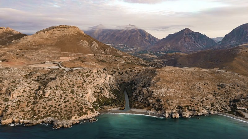 Aerial view of the palm-lined river meeting the sea at Preveli Beach
