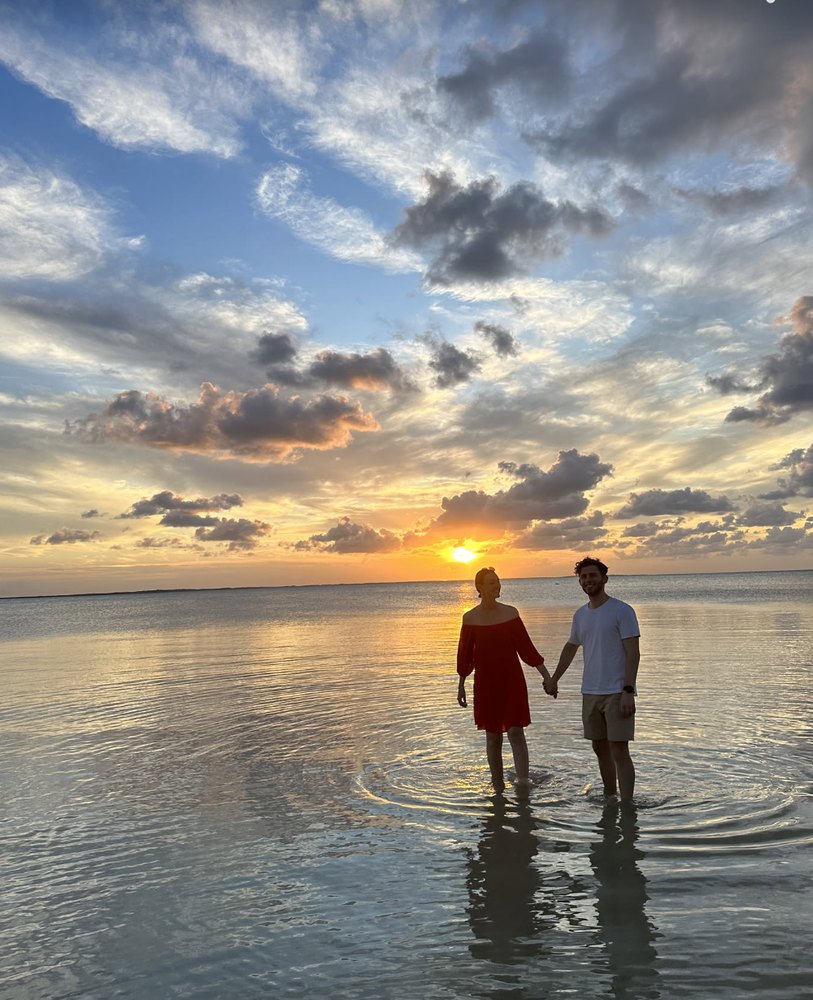 Leonard and Mona holding hands at sunset in the sea in Mexico