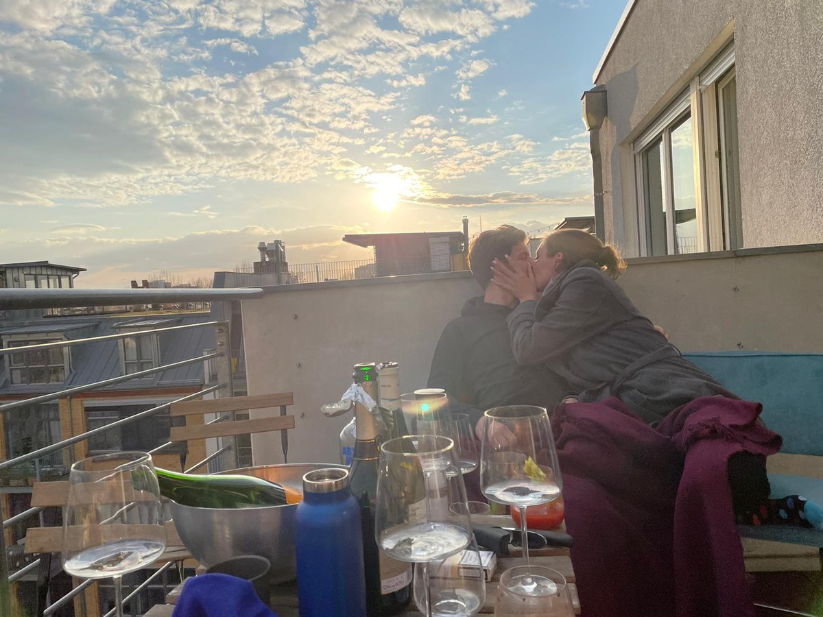Leonard and Mona kissing on a Berlin rooftop at sunset