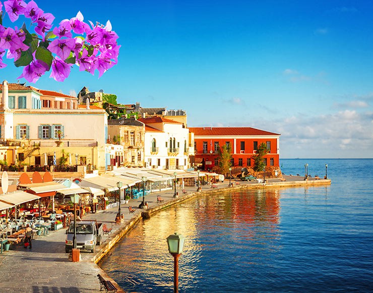 A sunlit harbour town on Crete with bougainvillea in bloom